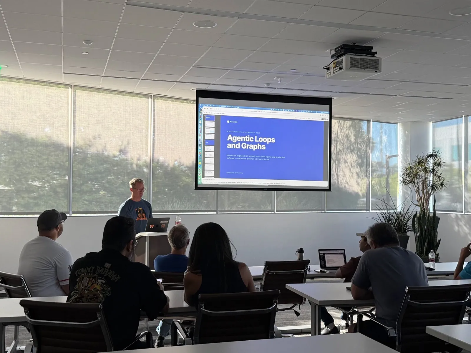 Marcus Hobbs presenting “Agentic Loops and Graphs” at the Irvine AI meetup, the title slide projected behind him